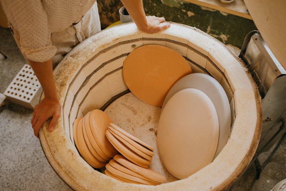 Close-up of pottery plates inside a ceramic kiln in an artisan workshop, highlighting craftsmanship and creativity.