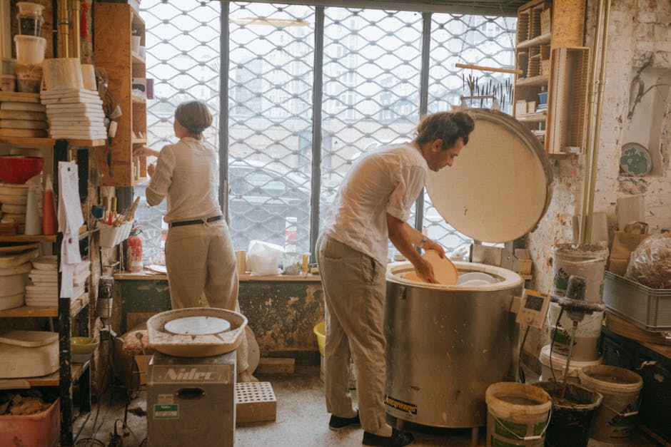 Artists engaged in pottery and ceramics in a warm, creative workspace.
