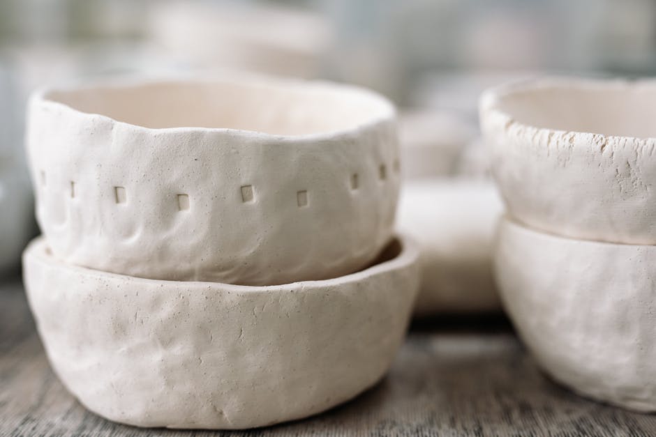 Stack of handmade clay bowls with a textured surface, showcasing craftsmanship.